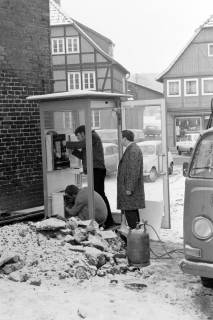 ARH Slg. Weber 02-129/0005, Männer bei der Reparatur einer Telefonzelle am Marktplatz neben dem Ratskeller, Gehrden, vor 1976