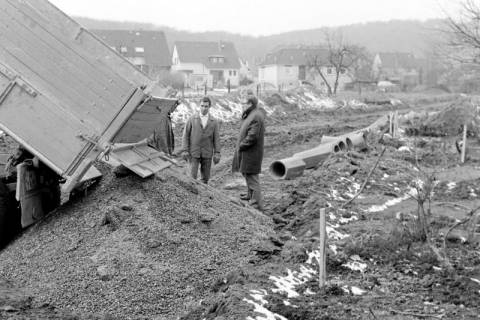 ARH Slg. Weber 02-130/0001, Zwei Männer neben einem Anhänger beim Abladen von Kies auf einem Baufeld, zwischen 1980/1990