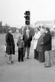 ARH Slg. Weber 02-132/0007, Stellv. Stadtdirektor Georg Weber sen. (links), Bürgermeister Helmut Oberheide (Mitte) und Stadtdirektor Hans Bildhauer (rechts daneben) mit weiteren Personen vor einer Ampel an der Schulstraße Ecke Lange-Feld-Straße, Gehrden, zwischen 1980/1990