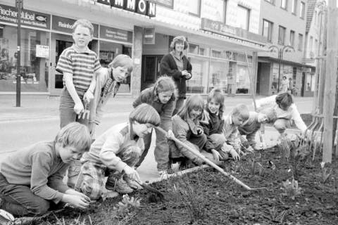 ARH Slg. Weber 02-132/0011, Kinder und Erwachsene bei der Neubepflanzung eines Blumenbeets an der Dammstraße, Gehrden, zwischen 1980/1990
