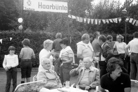 ARH Slg. Weber 02-139/0009, Bürgermeister Helmut Oberheide (sitzend, links) und weitere Personen bei einem Fest zum 30-jährigen Jubiläum der Straße Haarbünte, Gehrden, zwischen 1980/1990