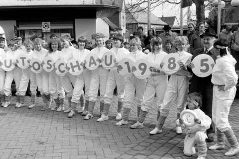 ARH Slg. Weber 02-145/0004, Edeltraud Schultz (rechts) vom Sportverein Gehrden hält mit ihrer Tanz- und Gymnastikgruppe und dem Bürgermeister Helmut Oberheide Schilder für die Autoschau hoch, Gehrden, 1985