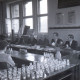 Archiv der Region Hannover, ARH NL Koberg 9670, Sechs Männer in Anzügen sitzen zwei jungen Personen in einem Lehrraum gegenüber, eventuell eine Prüfung, Hannover?
