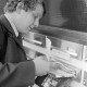 Archiv der Region Hannover, ARH NL Mellin 01-196/0002, Mann mit Zeitung an einem Briefkasten