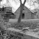Archiv der Region Hannover, ARH NL Mellin 02-076/0013, Blick durch eine zerstörte Mauer auf eine heruntergekommene Scheune (Varbitz?)