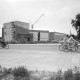 Archiv der Region Hannover, ARH NL Mellin 02-079/0010, Fahrradfahrer auf der Greyerstraße vor dem Neubau des Theaters an der Ilmenau mit dem Herzog-Ernst-Gymnasium dahinter und der St. Marien Kirche im Hintergrund, Uelzen