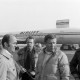 Archiv der Region Hannover, ARH NL Mellin 02-143/0005, Gruppe von Männern in einer Besprechung bei der Verladung eines Pferdes in eine Transportbox für ein Flugzeug