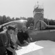 Archiv der Region Hannover, ARH NL Mellin 02-187/0010, Vier Männer des Feuerwehr-Flugdienstes Niedersachsen mit einer auf dem Flügel eines Flugzeuges ausgelegten Karte der Region Hannover auf dem Flugplatz Peine-Eddesse