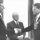 Stadtarchiv Neustadt a. Rbge., ARH Slg. Bartling 715, Bürgermeister Friedrich Temps mit Amtskette (re.) reicht dem Uhrmacher und Goldschmied Klaus Meyer (li.) die Hand, in der Mitte der Ehrenbürger Valentin Reichardt