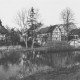 ARH Slg. Bartling 1076, Partie an der Kleinen Leine im Spätherbst, Blick vom Parkplatz am östlichen Ufer über den Fluss auf das gegenüberliegende Ufer, rechts die Brücke und die Weinhandlung Kollmeyer, links das Haus Schloßstraße 2 und der Kirchturm, Neustadt a. Rbge.