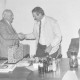 Stadtarchiv Neustadt a. Rbge., ARH Slg. Bartling 1323, Bürgermeister Henry Hahn aus Neustadt a. Rbge. überreicht dem Bürgermeister von Bergneustadt (?) als Gastgeschenk einen Geschenkkoffer, rechts am Konferenztisch sitzend ein unbekannter Mann, Bergneustadt