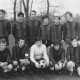 Stadtarchiv Neustadt a. Rbge., ARH Slg. Bartling 1979, Fußball-Mannschaft des 1. FC Mecklenhorst (nebeneinander kniend und stehend) im Tor eines Sportplatzes