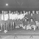 ARH Slg. Bartling 1989, Zwei Fußballmannschaften vor dem Anstoß am Mittelkreis nebeneinander aufgereiht und stehend, am Abend im Flutlicht, Blick von vorn