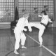 Stadtarchiv Neustadt a. Rbge., ARH Slg. Bartling 2075, Zweikampf-Training eines Paares der Karateka im Karate-Gi des OYAMA-Karate-Kai-Vereins in einer Sporthalle mit einer Fensterwand aus Glasbausteinen