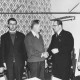 Stadtarchiv Neustadt a. Rbge., ARH Slg. Bartling 2091, Gruppenporträt von fünf Männern in der Garderobe einer Gaststätte, Gratulation des Hans Krull (? 2. v. r.) durch den Sportwart des Kreissportbundes Heinz Borsum (Mitte)