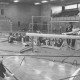 Stadtarchiv Neustadt a. Rbge., ARH Slg. Bartling 2117, Junge Turnerin im Längsspagat auf einem Schwebebalken in der TSV-Turnhalle, Neustadt a. Rbge.