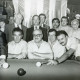 Stadtarchiv Neustadt a. Rbge., ARH Slg. Bartling 2249, Zwei Billardspieler (l. Günther Paschke, r. N. N.), umgeben von zahlreichen sitzenden und stehenden Zuschauern (darunter Bürgermeister Henry Hahn [linke Mitte]), beim Spiel am Tisch im Billardstudio, Neustadt a. Rbge.