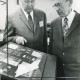 ARH Slg. Bartling 2258, Ein älterer Herr lässt sich von Emil Block (l.) die Exponate auf der Tafel einer Briefmarkenausstellung in der Schalterhalle der Kreissparkasse erklären, Neustadt a. Rbge.