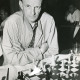 Stadtarchiv Neustadt a. Rbge., ARH Slg. Bartling 2263, Stadtmeister Hartmut Heyder? mit verschränkten Armen beim Spiel am Tisch vor dem Schachbrett sitzend, Neustadt a. Rbge.