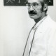 ARH Slg. Bartling 2411, Kinderarzt Dr. Suohi Ünal im weißen Kittel mit umgehängtem Stethoskopl, im Hintergrund an der Wand Bild von Hühnern in Batik-Technik, Neustadt a. Rbge.