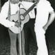 Stadtarchiv Neustadt a. Rbge., ARH Slg. Bartling 2916, Gymnasium an der Gaußstraße, Gruppe von drei afrikanischen Besuchsschülern steht und singt mit Gitarre am Mikrofon, Neustadt a. Rbge.