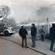 Stadtarchiv Neustadt a. Rbge., ARH Slg. Bartling 3436, Drei Polizisten vor der Einfahrt zur Parkpalette, durch die dichter Rauch quillt; links ein Löschfahrzeug der Feuerwehr mit offenem Seitenteil, Neustadt a. Rbge.