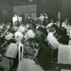 Stadtarchiv Neustadt a. Rbge., ARH Slg. Bartling 3671, Aufführung des Schulorchesters des Gymnasiums (?) unter der Leitung von N. N., Blick von der linken Seite, im Hintergrund auf der Bühne die Kulisse eines Hauses, Neustadt a. Rbge.