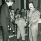 Stadtarchiv Neustadt a. Rbge., ARH Slg. Bartling 3677, Begrüßung des "Schimpansen-Opas" Robby (an der Hand des Zirkusdirektors Köhler) vom Circus Belly durch den Conferencier einer größeren Versammlung, Neustadt a. Rbge.