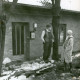 Stadtarchiv Neustadt a. Rbge., ARH Slg. Bartling 3690, Mann und Frau vor einem Haus mit der Nr. 29, an dessen Haustür das winterliche Hochwasser heranreicht