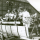 Stadtarchiv Neustadt a. Rbge., ARH Slg. Bartling 3707, Umzug am Erntefest (?), Gruppe von Personen auf einem renovierten Pferdewagen vor der Fachwerk-Giebelwand eines Bauernhauses, Mandelsloh