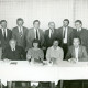 ARH Slg. Bartling 3765, Gruppenporträt des Ortsrates Poggenhagen an einem Tisch sitzend bzw. hinter einem Tisch stehend in einem Saal, Poggenhagen