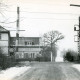Stadtarchiv Neustadt a. Rbge., ARH Slg. Bartling 3798, Beschrankter Bahnübergang am Fritz-Blume-Weg, leicht verschneit, Blick auf das Gebäude der Post, Poggenhagen