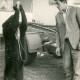 Stadtarchiv Neustadt a. Rbge., ARH Slg. Bartling 3889, Kleiner Familienzirkus im Winterlager am Dammkrug, der Junior vor den Wohnwagen mit einem jungen Bären, der aus einer Flasche trinkt, Bordenau
