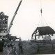 Stadtarchiv Neustadt a. Rbge., ARH Slg. Bartling 3973, Bockwindmühle nach Abnahme der Dachkonstruktion durch einen Autokran Gottwald AMK 56-42 der Firma Schlamann, im Vordergrund drei Leute eines Filmteams, Dudensen
