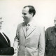 Stadtarchiv Neustadt a. Rbge., ARH Slg. Bartling 4085, Händeschütteln zwischen Heinrich Dannenberg, Gemeindedirektor von Eilvese a. D. (l.) und Ortsbürgermeister Meissner, Zuschauer: Ortsrat Jurk, Eilvese