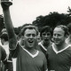 Stadtarchiv Neustadt a. Rbge., ARH Slg. Bartling 4281, Zwei Spieler vom Fußballverein Germania recken den gewonnenen jubelnd Pokal in die Höhe, Helstorf