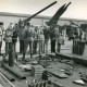 ARH Slg. Bartling 4384, Tag der offenen Tür, Ausstellung der Bordausrüstung eines Panzers auf dem Vorplatz der Panzer-Hallen , Blick über die auf dem Boden ausgelegten Gegenstände auf die vor den Hallen stehenden schweren Geschütze, Luttmersen