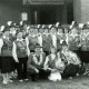 Stadtarchiv Neustadt a. Rbge., ARH Slg. Bartling 4482, Gruppenbild mit zahlreichen uniformierten Schützinnen mit Hut und dem Schützenkönig vor dem Eingang zum Schützenhaus des Schützenvereins, Mariensee