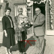 Stadtarchiv Neustadt a. Rbge., ARH Slg. Bartling 4511, Überreichung eines Blumenstraußes zur Eröffnung der Poststelle an die Leiterin durch eine Frau und einen Mann vor dem Eingang, Mardorf