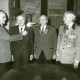 Stadtarchiv Neustadt a. Rbge., ARH Slg. Bartling 4710, Ehrung von drei Jubilaren durch den 1. Vorsitzenden des Schützenvereins Manfred Kettner (l.) in einem Saal mit Musikbox, Nöpke