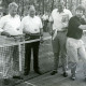 ARH Slg. Bartling 4801, Vier Männer beim Ausprobieren von Tennisbällen und Tennisschlägern nebeneinander am Netz stehend auf dem neu errichteten Tennisplatz (2 Ex.), Otternhagen