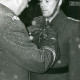 Stadtarchiv Neustadt a. Rbge., ARH Slg. Bartling 4860, Fliegerhorst, Verleihung eines Ordens an einen Soldaten (mit Helm) durch einen Major (mit Schiffchen), die Uniform besprenkelt mit Schneegraupel, Poggenhagen