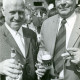 Stadtarchiv Neustadt a. Rbge., ARH Slg. Bartling 4889, Doppelporträt von Heinrich Fischhöfer (r.) und W. Feise (l.) nebeneinander mit Bier bzw. Schnaps beim Scheibenannageln auf dem Schützenfest, Scharrel