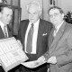 Archiv der Region Hannover, ARH Slg. Weber 02-107/0020, V.l. Stadtdirektor Hans Bildhauer, Bauamtsleiter Hermann Nasemann und Bürgermeister Heinrich Berkefeld mit eingerahmten Ehrenurkunden bei der Verabschiedung von Nasemann in den Ruhestand, Gehrden