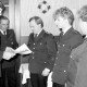 Archiv der Region Hannover, ARH Slg. Weber 02-120/0001, Gehrdens Stadtbrandmeister Fritz Narten (links) und Ortsbrandmeister Friedrich Volker überreichen Beförderungsurkunden bei der Jahreshauptversammlung der Ortsfeuerwehr, Northen